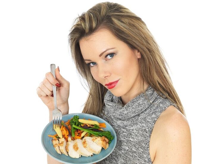 djevojka koja jede piletinu s povrćem za mršavljenje